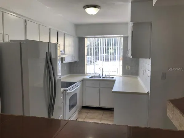a kitchen with stainless steel appliances granite countertop a refrigerator a sink and a stove