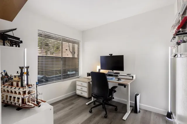 a view of a workspace with furniture and a window