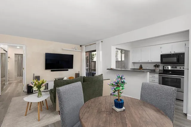 a living room with furniture a flat screen tv and a window