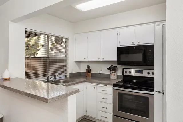 a kitchen with a sink stove and microwave