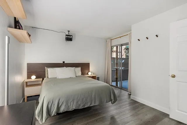 a bedroom with a bed and wooden floor