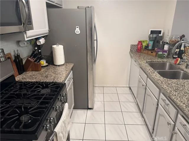a kitchen with granite countertop a stove and a sink