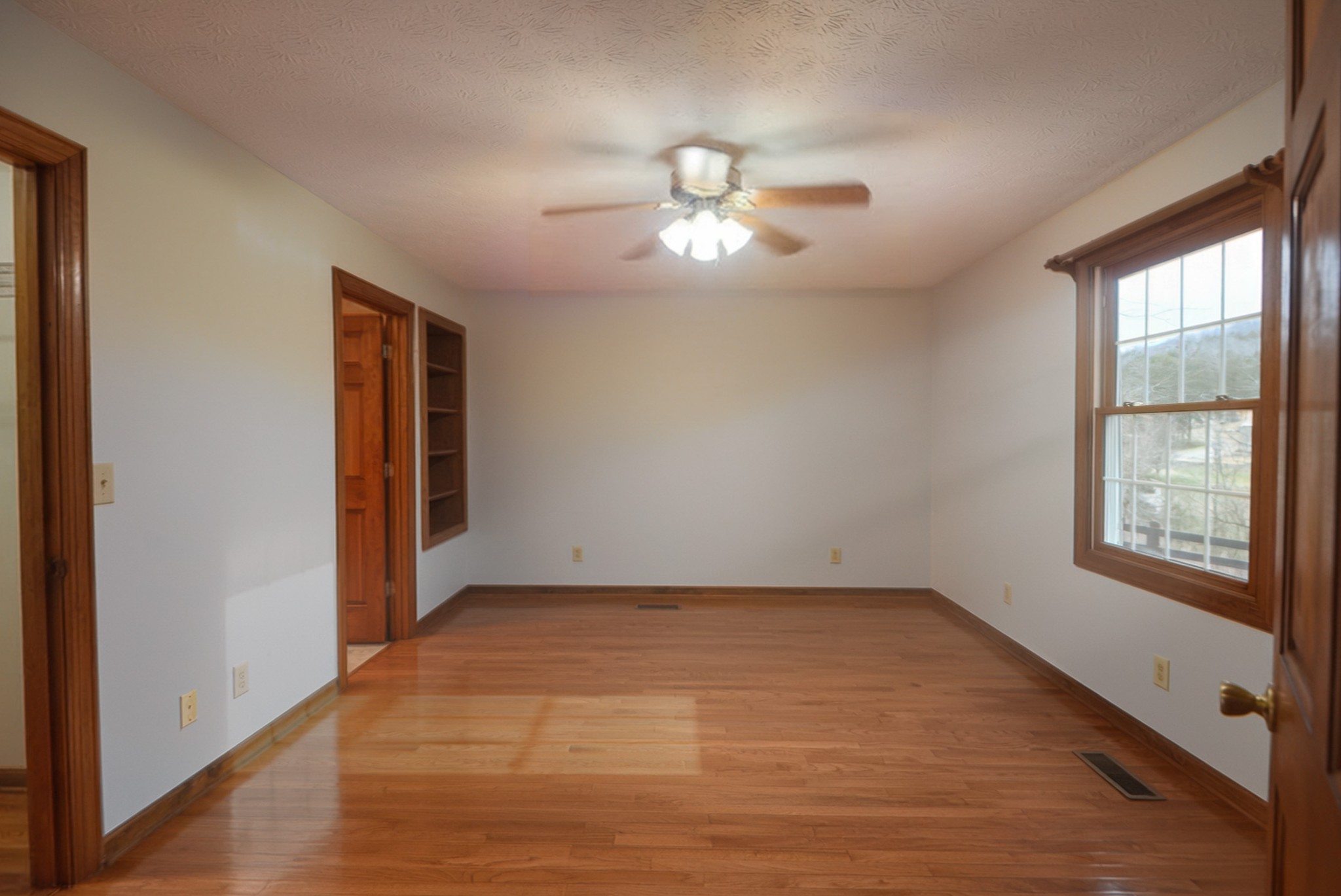 6680 Walker Creek Road Alexandria, TN 37012 - Photo 26 of 76 a view of empty room with wooden floor and fan