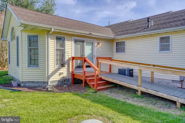 a backyard of a house with wooden fence and a bench