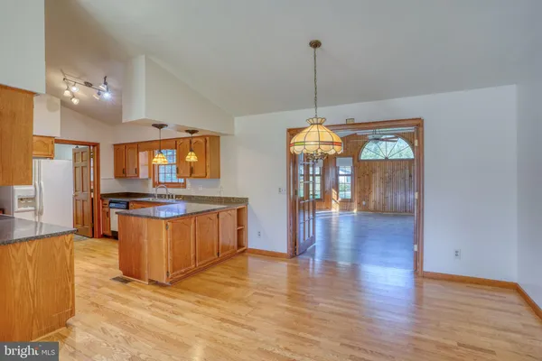 a view of living room with kitchen island granite countertop wooden floor