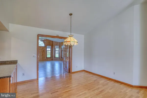 a hallway with wooden floor chandelier and entryway
