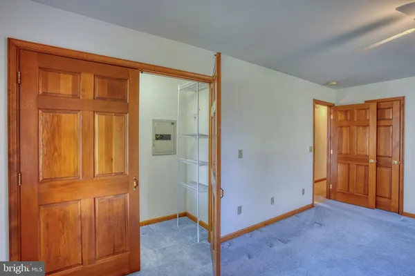 an empty room with wooden floor and closet area