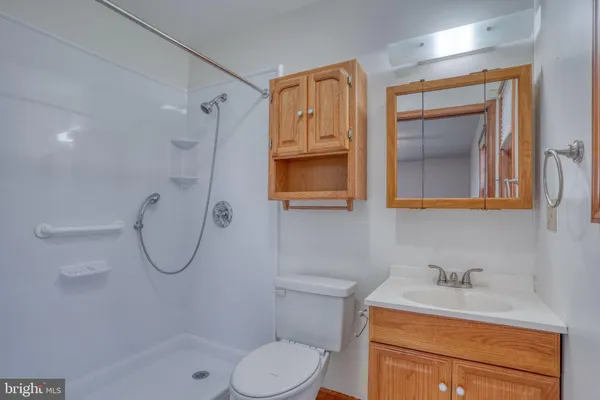 a bathroom with a granite countertop toilet sink and mirror