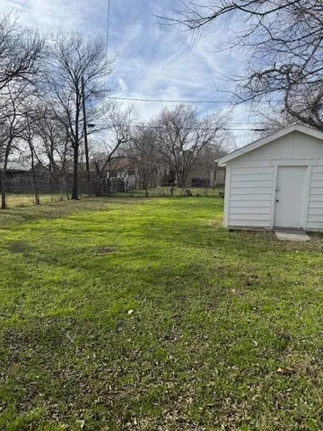a yard that is sitting in a large yard with large trees