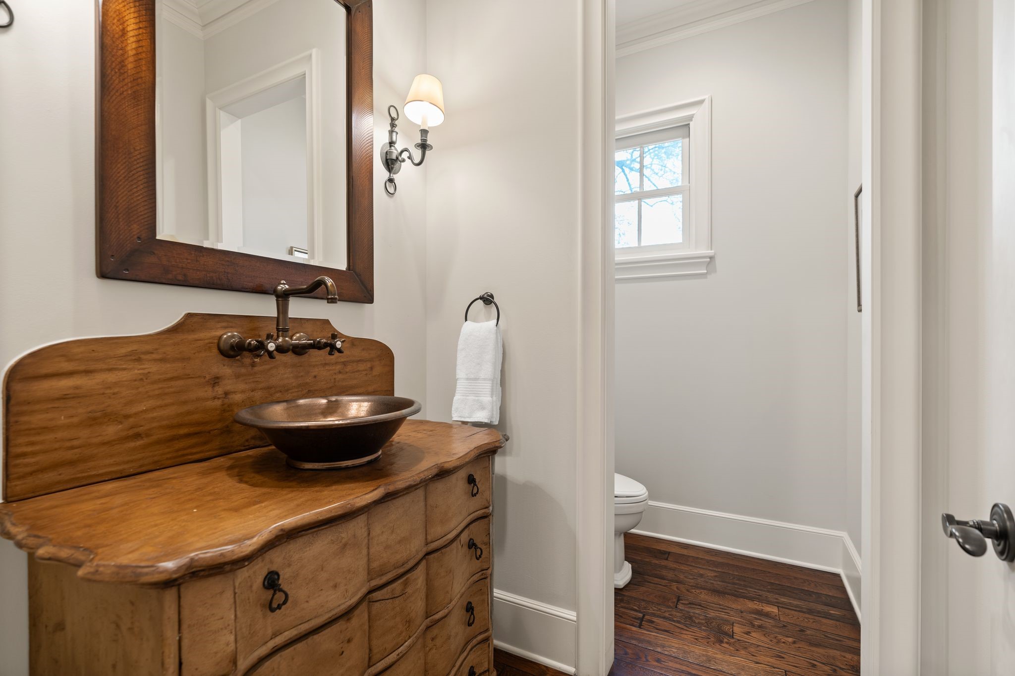 11402 Taylorcrest Road Houston, TX 77024 - Photo 22 of 44 Conveniently located along the hallway leading to the primary suite, this formal powder bath features an antique chest vanity w/ vessel sink, creating a distinctive focal point. Hardwood floors & a privacy window w/ plantation shutters complete the space w/ warmth & character. One of two powder baths on the first floor.