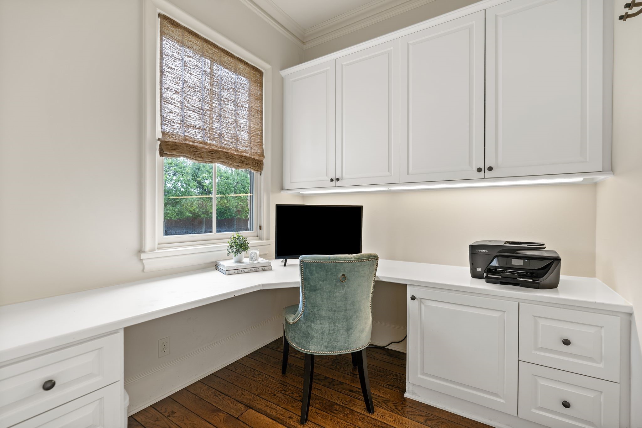 11402 Taylorcrest Road Houston, TX 77024 - Photo 34 of 44 Thoughtfully designed planning/work station on the first floor features a built-in desk w/ expansive counter space & abundant storage cabinets. Hardwood floors & window coverings create a polished, functional setting—ideal for a home office, study space or everyday organization hub.