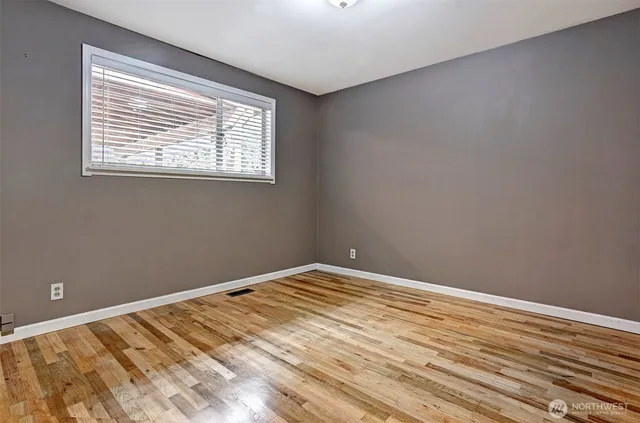 a view of a room with wooden floor and windows