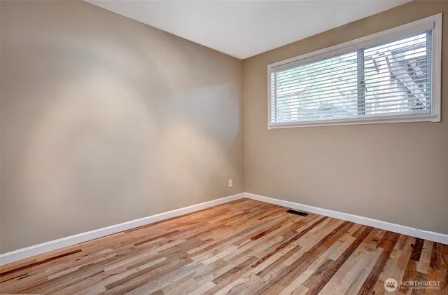 a view of a room with wooden floor and a window