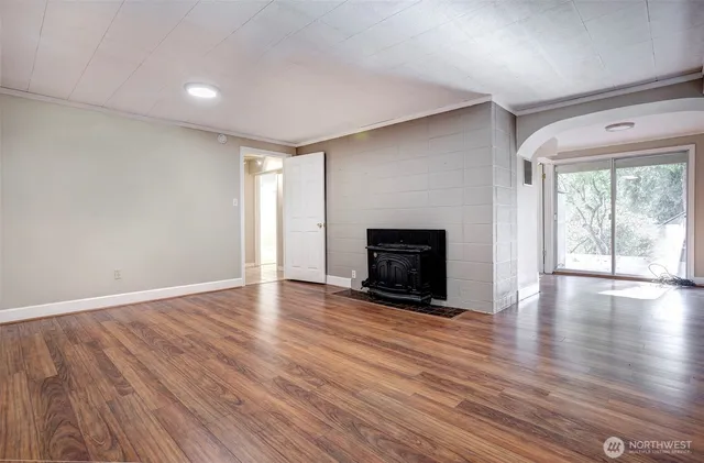 a view of empty room with wooden floor and fireplace