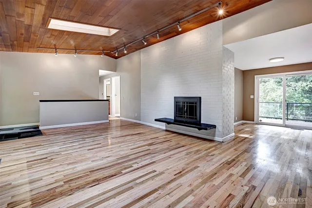 a view of empty room with wooden floor and fireplace
