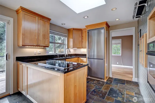 a kitchen with granite countertop a refrigerator and a sink