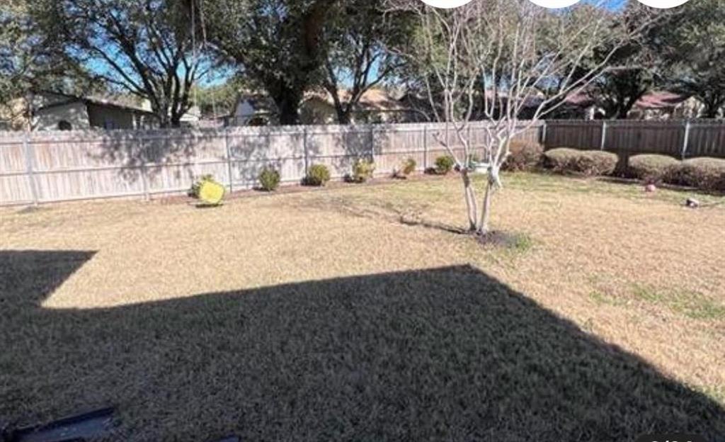 4422 Galaxie Road Garland, TX 75044 - Photo 10 of 11 Expansive backyard featuring a privacy fence, established shrubbery, mature trees, and ample open space