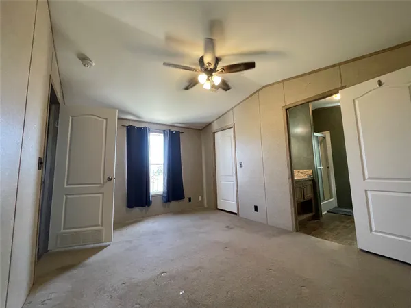 a view of a livingroom with a ceiling fan and kitchen view