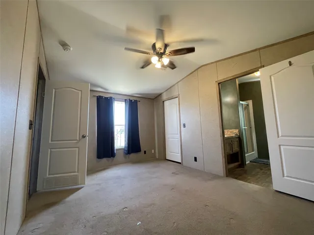 a view of a livingroom with a ceiling fan and kitchen view