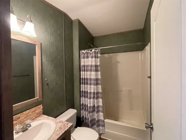 a bathroom with a shower and toilet