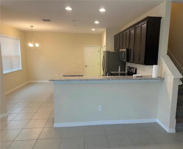 a kitchen with kitchen island a sink a counter and a refrigerator