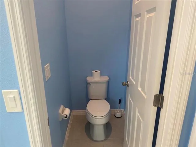 a white toilet sitting in a bathroom next to a sink