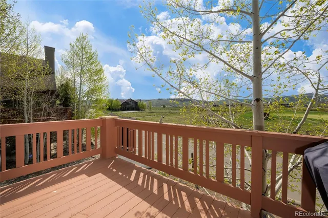 a view of a balcony with wooden floor and furniture