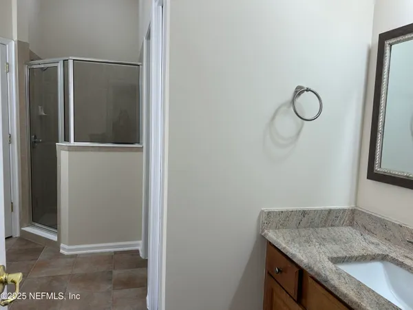 a bathroom with a granite countertop sink and a mirror