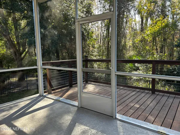 a view of a balcony with floor to ceiling window next to a yard