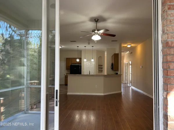 a view of a hallway with wooden floor and chandelier