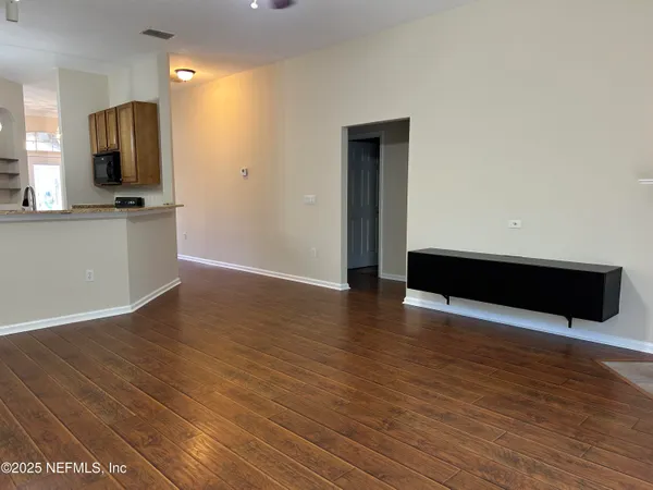 a view of kitchen with wooden floor and electronic appliances
