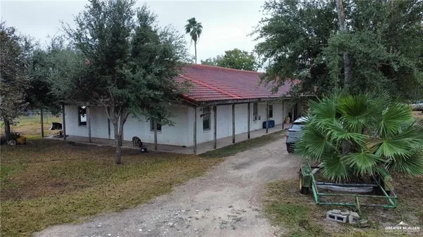 a view of a patio with table and chairs and a large tree