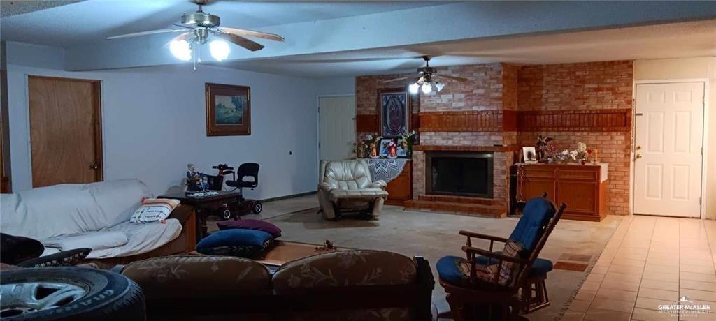 5906 North Brushline Road Mission, TX 78574 - Photo 24 of 29 a living room with furniture a fireplace and a chandelier