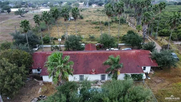 a aerial view of a house with plants and large trees