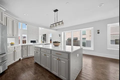a kitchen with white cabinets and wooden floor
