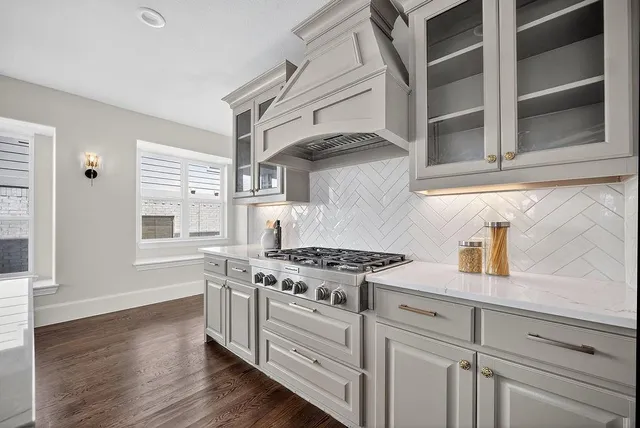 a kitchen with stainless steel appliances granite countertop a stove and a white cabinets
