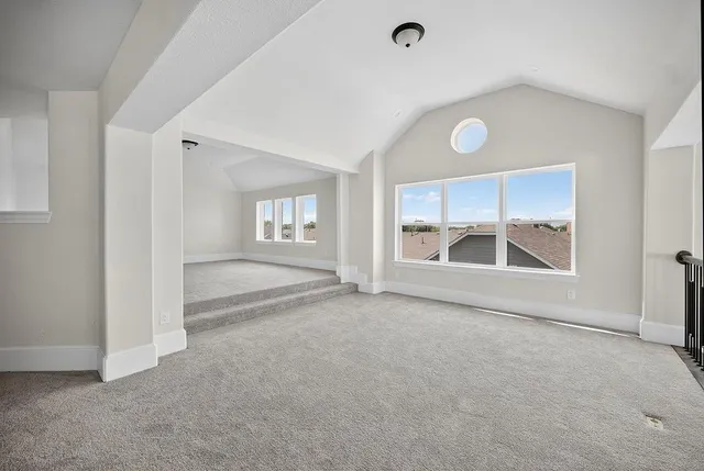 an empty room with a fireplace and large window