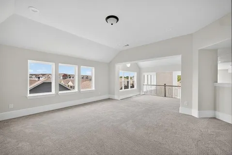 a view of a big room with windows and chandelier fan