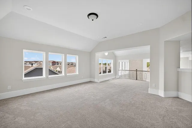 a view of a big room with windows and chandelier fan
