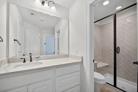 a bathroom with a double vanity sink toilet and shower