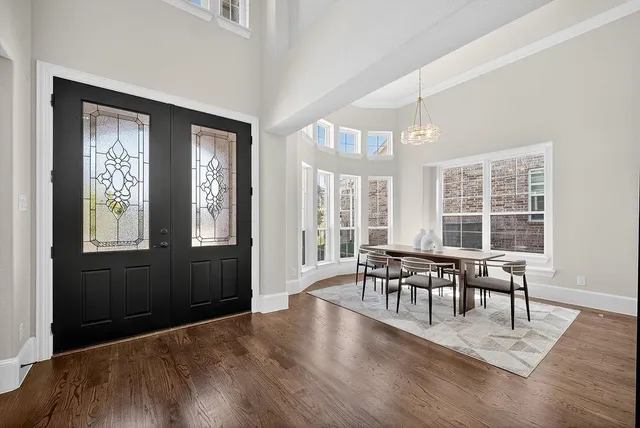 a dining room with wooden floor a glass table and chairs
