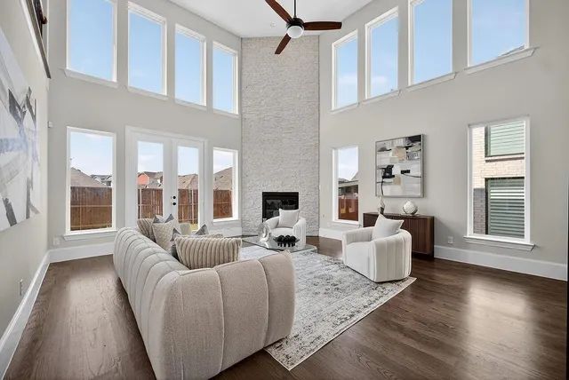 a living room with furniture wooden floor and a large window