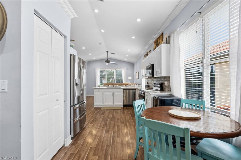 1770 Ribbon Fan Lane Naples, FL 34119 - Photo 13 of 37 a kitchen with white cabinets and stainless steel appliances