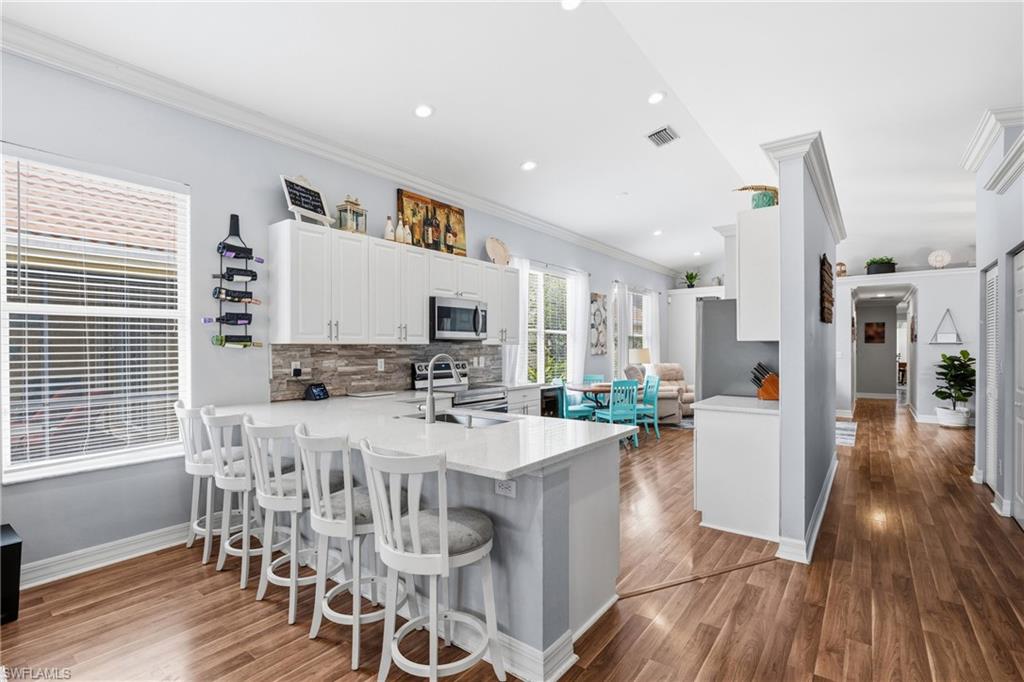1770 Ribbon Fan Lane Naples, FL 34119 - Photo 14 of 37 a view of a dining room with furniture and wooden floor