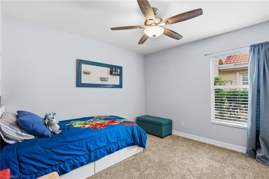 1770 Ribbon Fan Lane Naples, FL 34119 - Photo 23 of 37 a bedroom with a bed and a chandelier