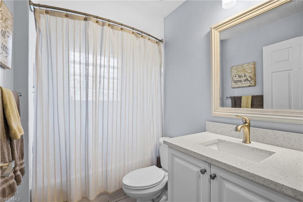1770 Ribbon Fan Lane Naples, FL 34119 - Photo 25 of 37 a bathroom with a granite countertop sink and a mirror