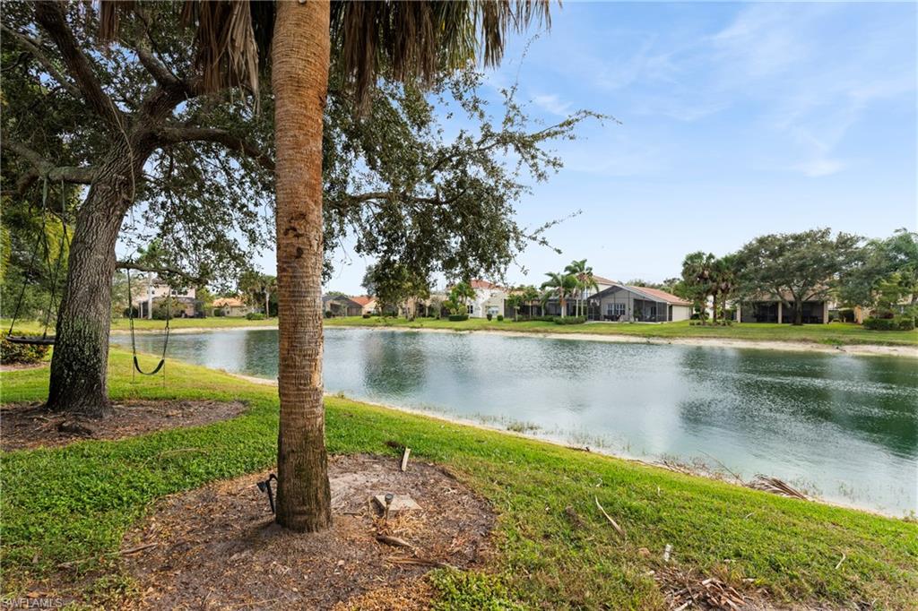 1770 Ribbon Fan Lane Naples, FL 34119 - Photo 28 of 37 a view of a lake with a house in the background