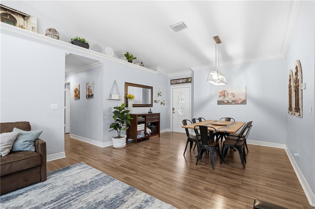 1770 Ribbon Fan Lane Naples, FL 34119 - Photo 10 of 37 a view of a dining room with furniture and wooden floor