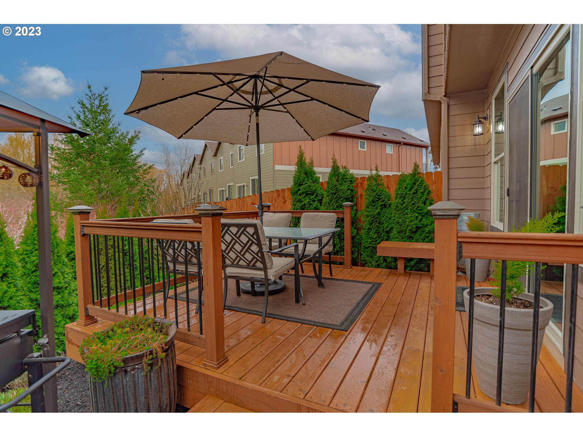 4020 North 1st Way Ridgefield, WA 98642 - Photo 25 of 32 a view of a roof deck with table and chairs under an umbrella with wooden floor