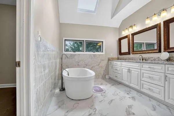 a bathroom with a granite countertop toilet sink and mirror